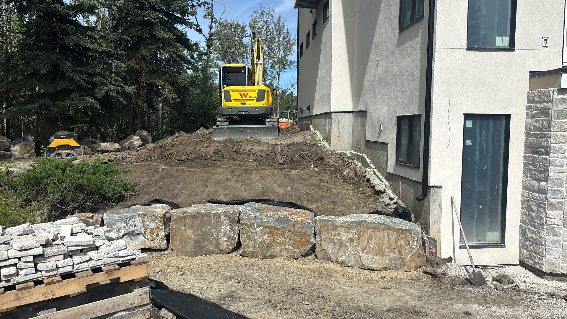Backyard regraded with boulder retaining wall