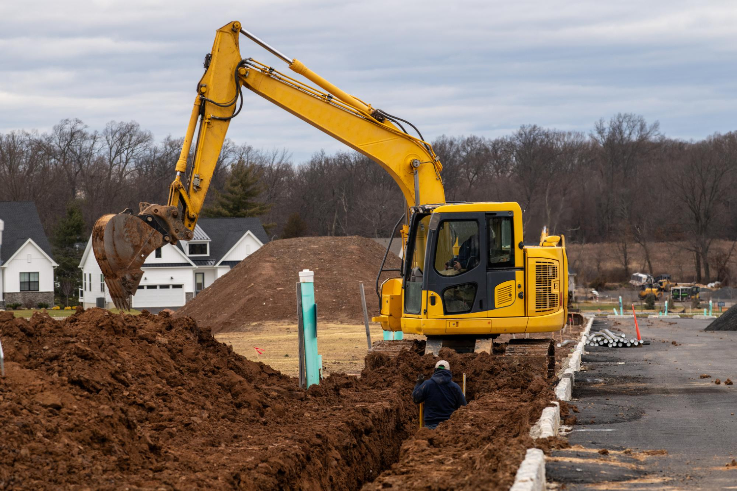 Excavator trenching in a residential neighbourhood