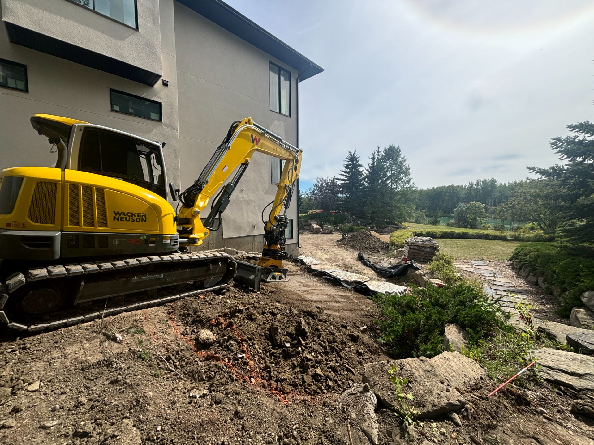 Adept excavator working beside a Calgary home